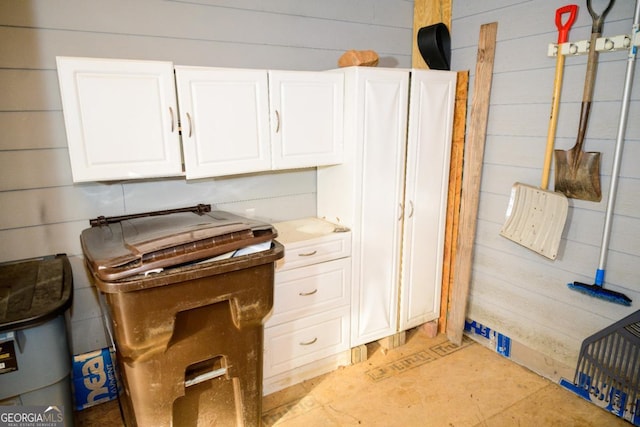 kitchen with white cabinets and wood walls