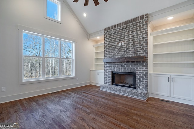 unfurnished living room with ceiling fan, a fireplace, dark hardwood / wood-style flooring, and high vaulted ceiling