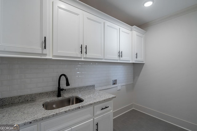 washroom featuring sink, cabinets, ornamental molding, dark tile patterned floors, and hookup for a washing machine