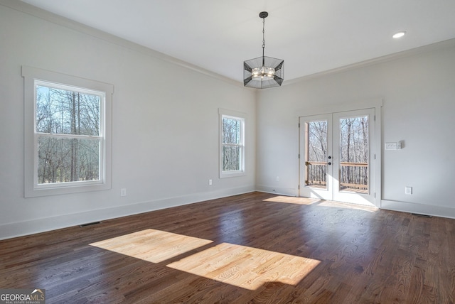 empty room with dark hardwood / wood-style flooring, crown molding, and a wealth of natural light