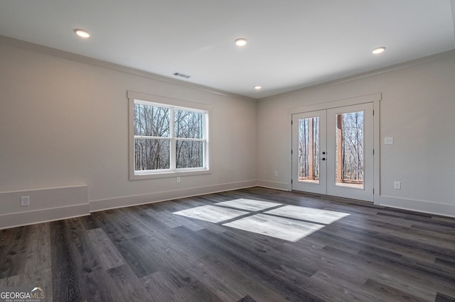 empty room with french doors, plenty of natural light, crown molding, and dark wood-type flooring