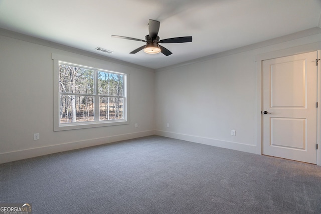 carpeted spare room featuring crown molding and ceiling fan