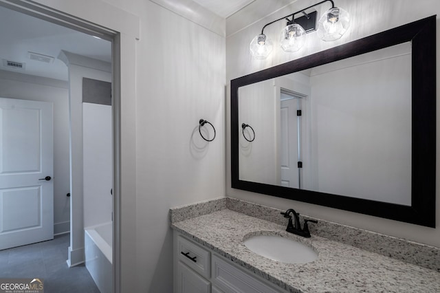 bathroom with vanity, a bath, and tile patterned flooring