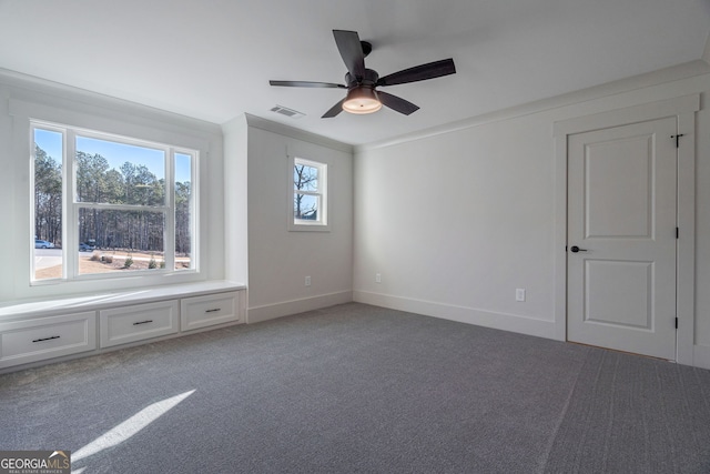 carpeted spare room featuring ornamental molding and ceiling fan