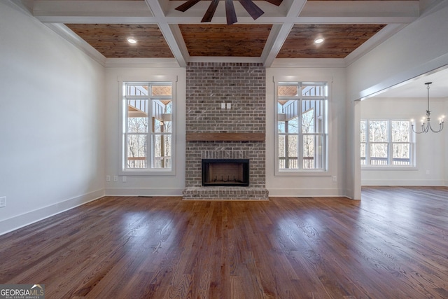 unfurnished living room with dark hardwood / wood-style floors, plenty of natural light, coffered ceiling, and beam ceiling