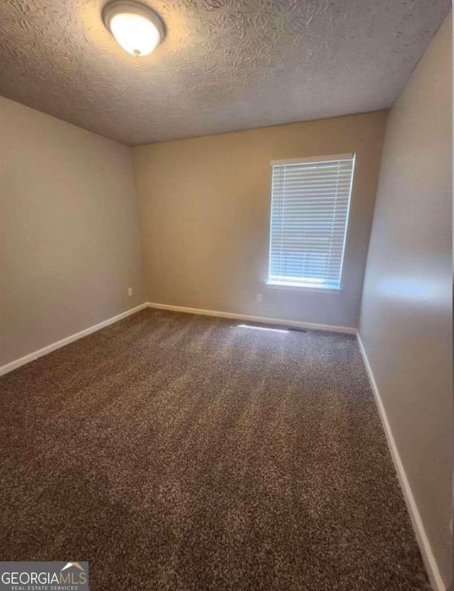 carpeted empty room with a textured ceiling