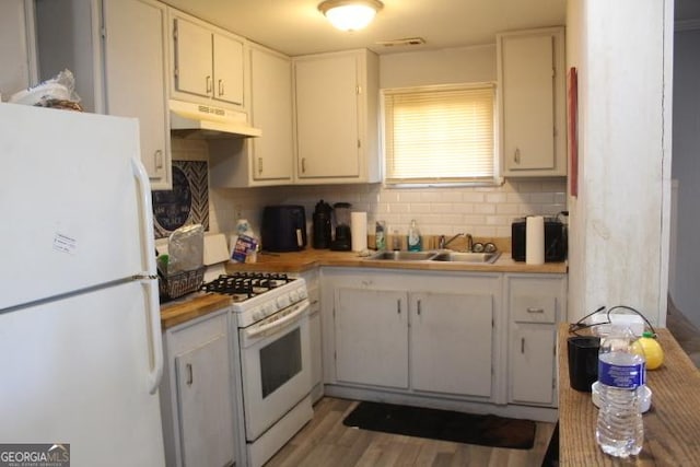 kitchen featuring white cabinetry, sink, white appliances, and light wood-type flooring