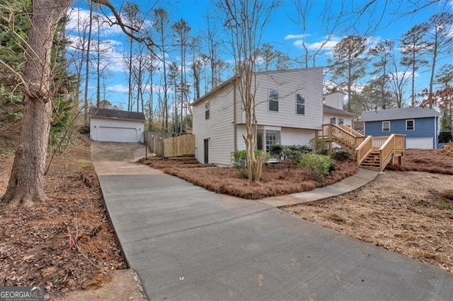 view of home's exterior featuring a garage, an outbuilding, and a deck