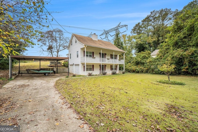 colonial home with a porch, a carport, and a front yard