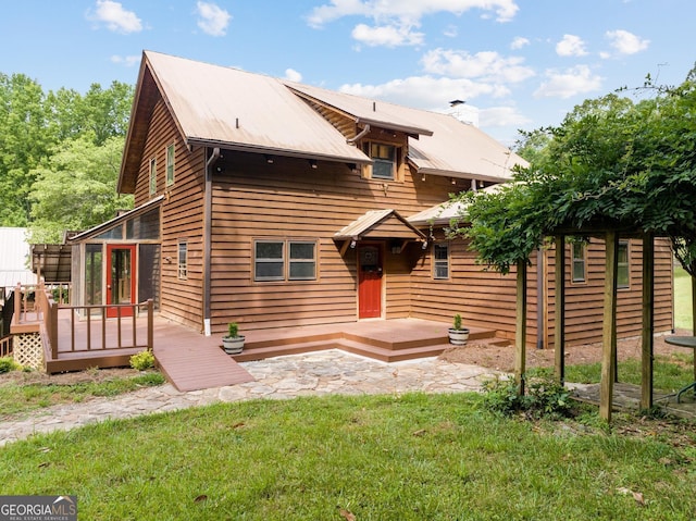 rear view of property with a yard and a deck