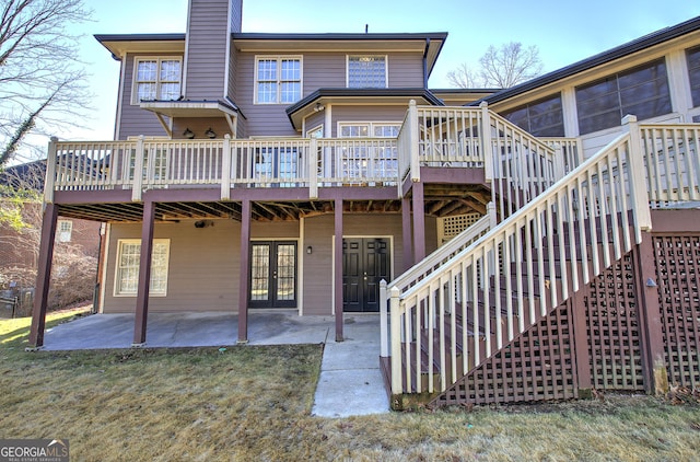 rear view of house featuring a patio, a deck, and a lawn