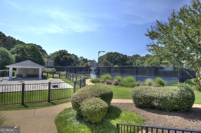 view of community featuring a gazebo, a lawn, and tennis court