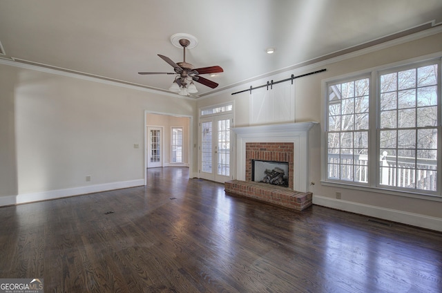 unfurnished living room with dark hardwood / wood-style flooring, a wealth of natural light, and ornamental molding