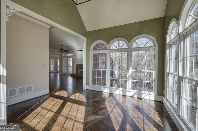 sunroom / solarium featuring ceiling fan, lofted ceiling, and a brick fireplace