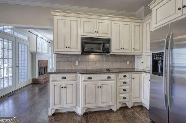 kitchen with dark hardwood / wood-style floors, dark stone countertops, stainless steel fridge, and decorative backsplash