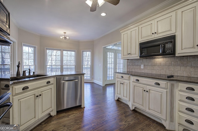 kitchen with crown molding, dark stone countertops, backsplash, stainless steel appliances, and dark hardwood / wood-style flooring