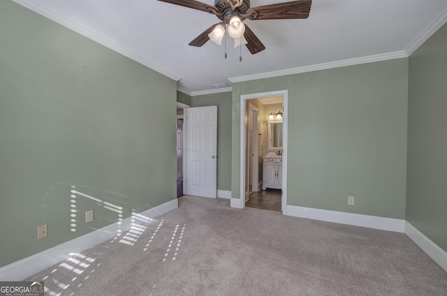 unfurnished bedroom with sink, crown molding, ensuite bath, ceiling fan, and light colored carpet