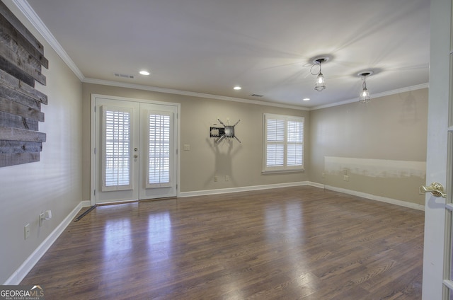 empty room featuring crown molding, dark wood-type flooring, and french doors