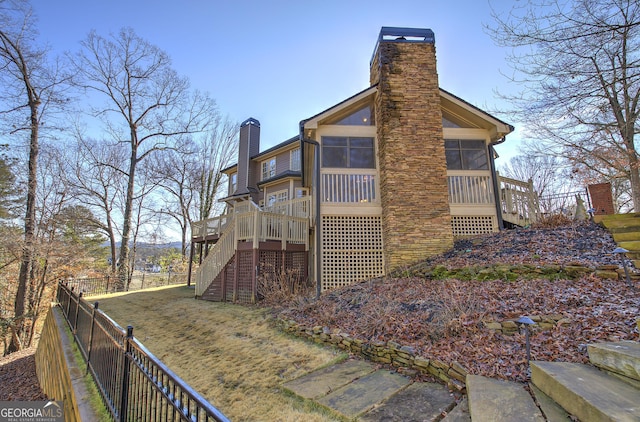 view of side of property featuring a sunroom and a deck