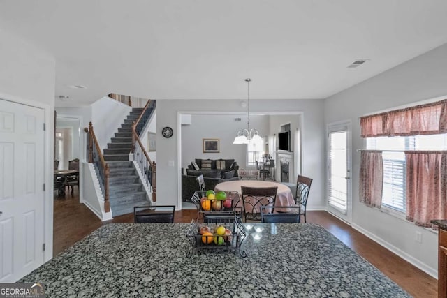 dining area with dark wood-type flooring and a chandelier