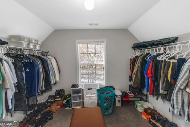 walk in closet with lofted ceiling and carpet