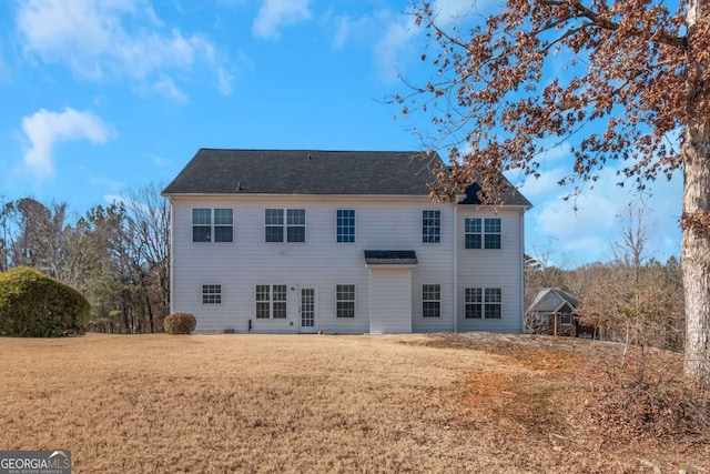 rear view of property featuring a yard