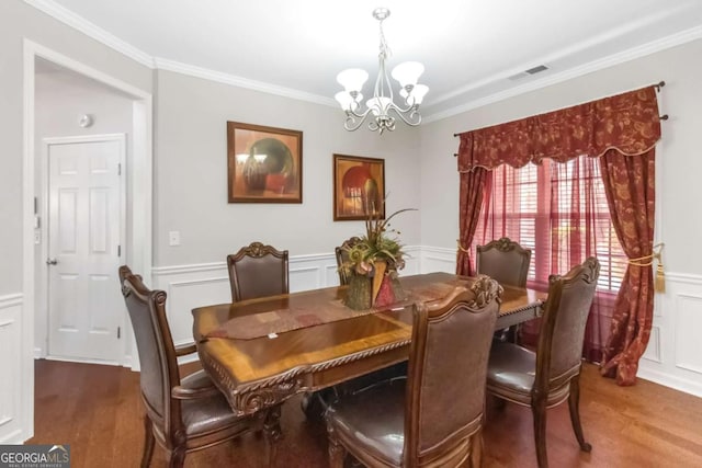 dining room with a notable chandelier, crown molding, and wood-type flooring