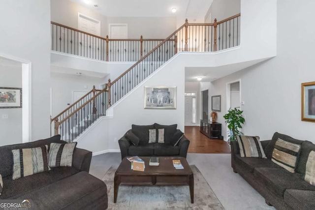 living room with carpet floors and a towering ceiling