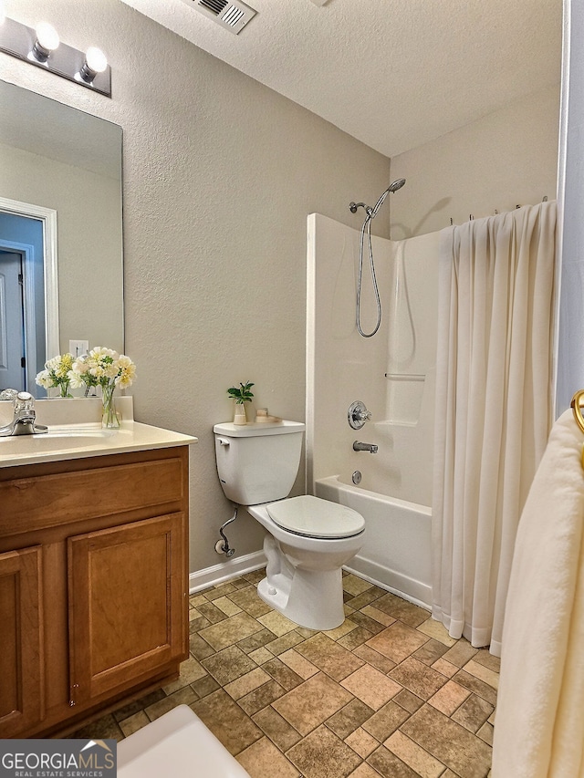 full bathroom with vanity, toilet, a textured ceiling, and shower / bath combo with shower curtain