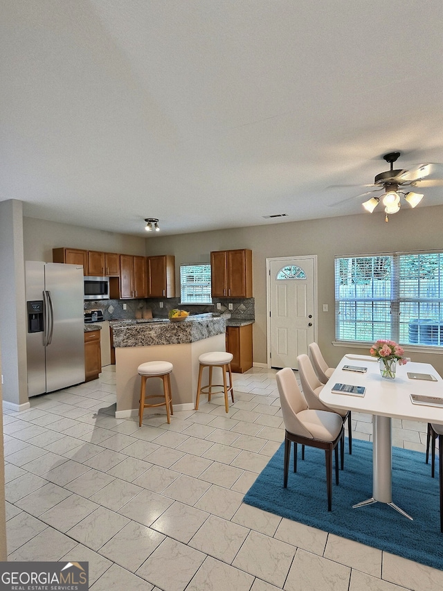 tiled dining area featuring a wealth of natural light and ceiling fan