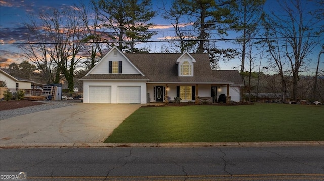 cape cod house with a garage and a lawn