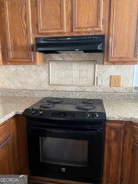 kitchen with backsplash, black range with electric stovetop, and exhaust hood