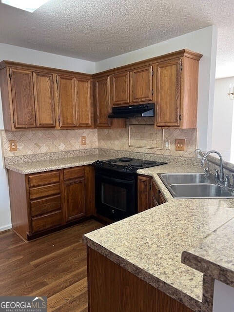 kitchen featuring sink, dark hardwood / wood-style floors, black electric range, a textured ceiling, and kitchen peninsula