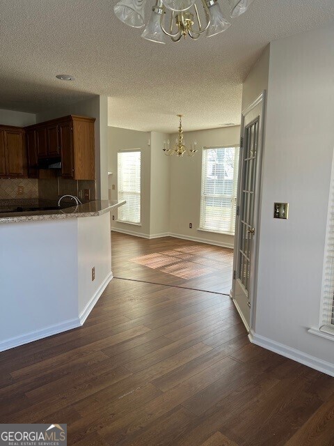 kitchen featuring tasteful backsplash, dark hardwood / wood-style floors, a wealth of natural light, and a notable chandelier