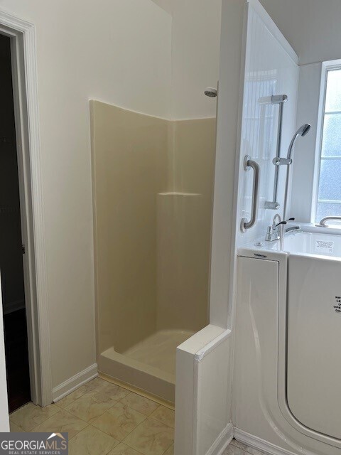 bathroom featuring tile patterned floors and separate shower and tub