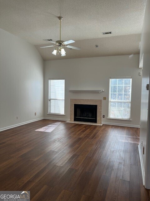 unfurnished living room with dark hardwood / wood-style flooring, a high end fireplace, lofted ceiling, and ceiling fan