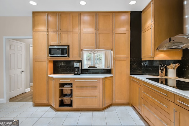 kitchen featuring stainless steel microwave, backsplash, light tile patterned floors, and black electric cooktop