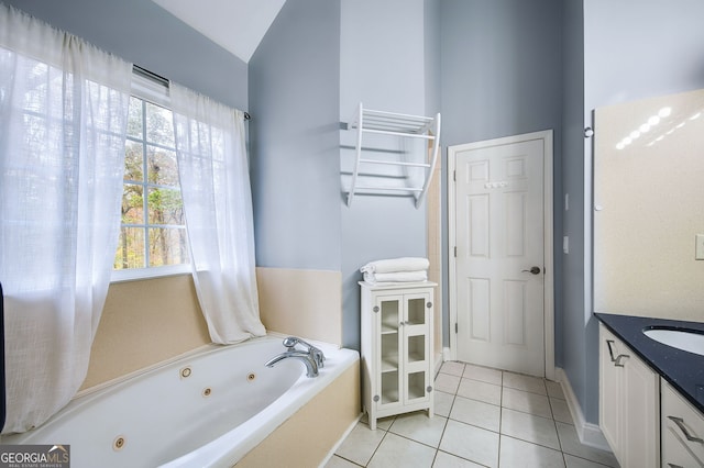 bathroom featuring vaulted ceiling, vanity, tile patterned floors, and a tub to relax in