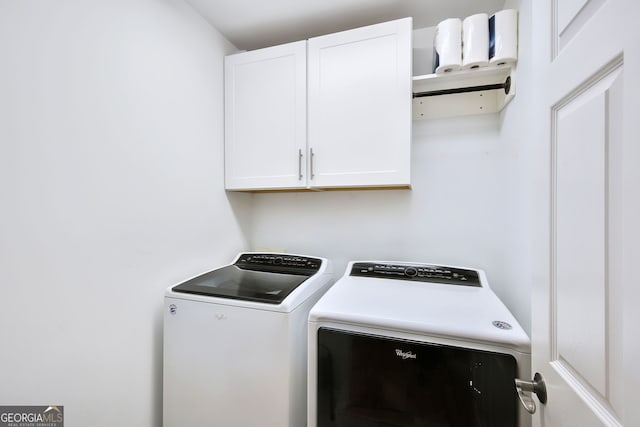 laundry room featuring washer and dryer and cabinets