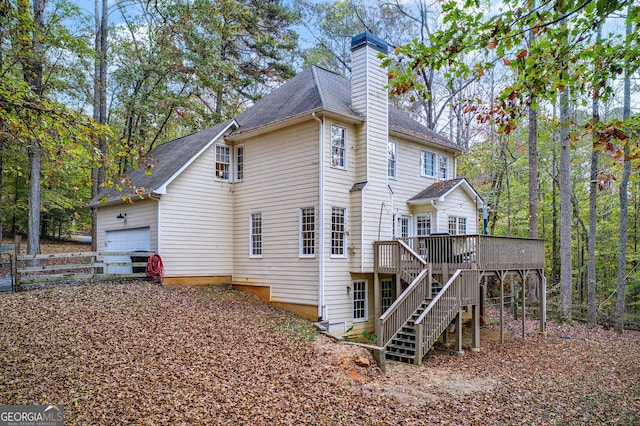 rear view of house featuring a garage and a deck