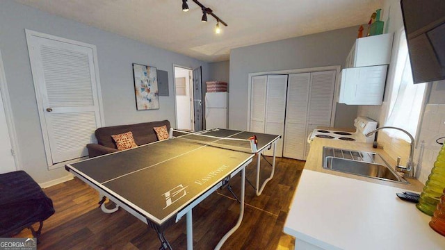 game room featuring sink, dark wood-type flooring, and track lighting