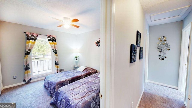 carpeted bedroom with ceiling fan and a textured ceiling