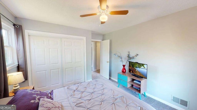 carpeted bedroom with ceiling fan and a closet