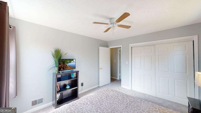 bedroom featuring light colored carpet, a closet, and ceiling fan