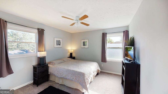 carpeted bedroom featuring a textured ceiling and ceiling fan