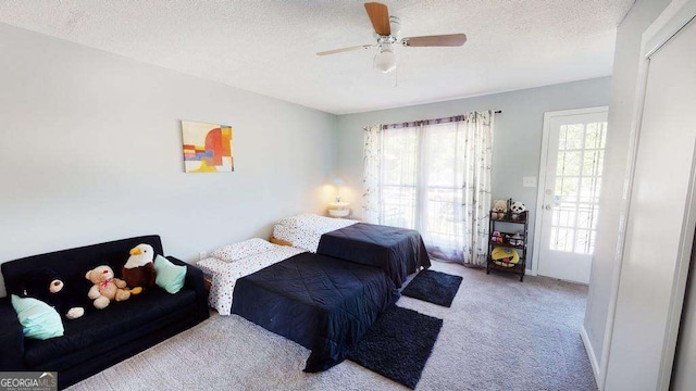 bedroom with light colored carpet, a textured ceiling, and ceiling fan