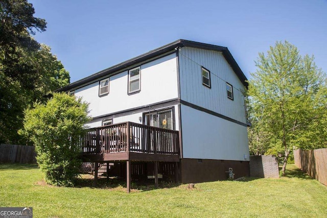 rear view of property featuring a wooden deck and a yard