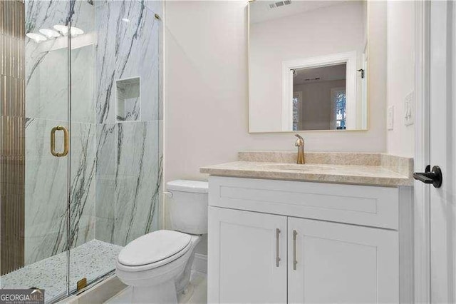 bathroom with vanity, an enclosed shower, and toilet