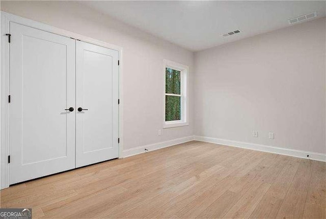 unfurnished bedroom with a closet and light hardwood / wood-style flooring