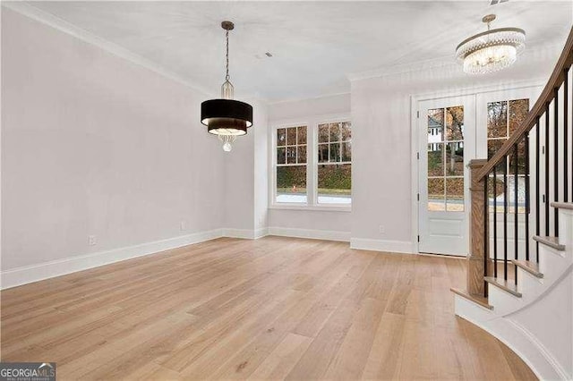 foyer featuring a notable chandelier, crown molding, and a healthy amount of sunlight